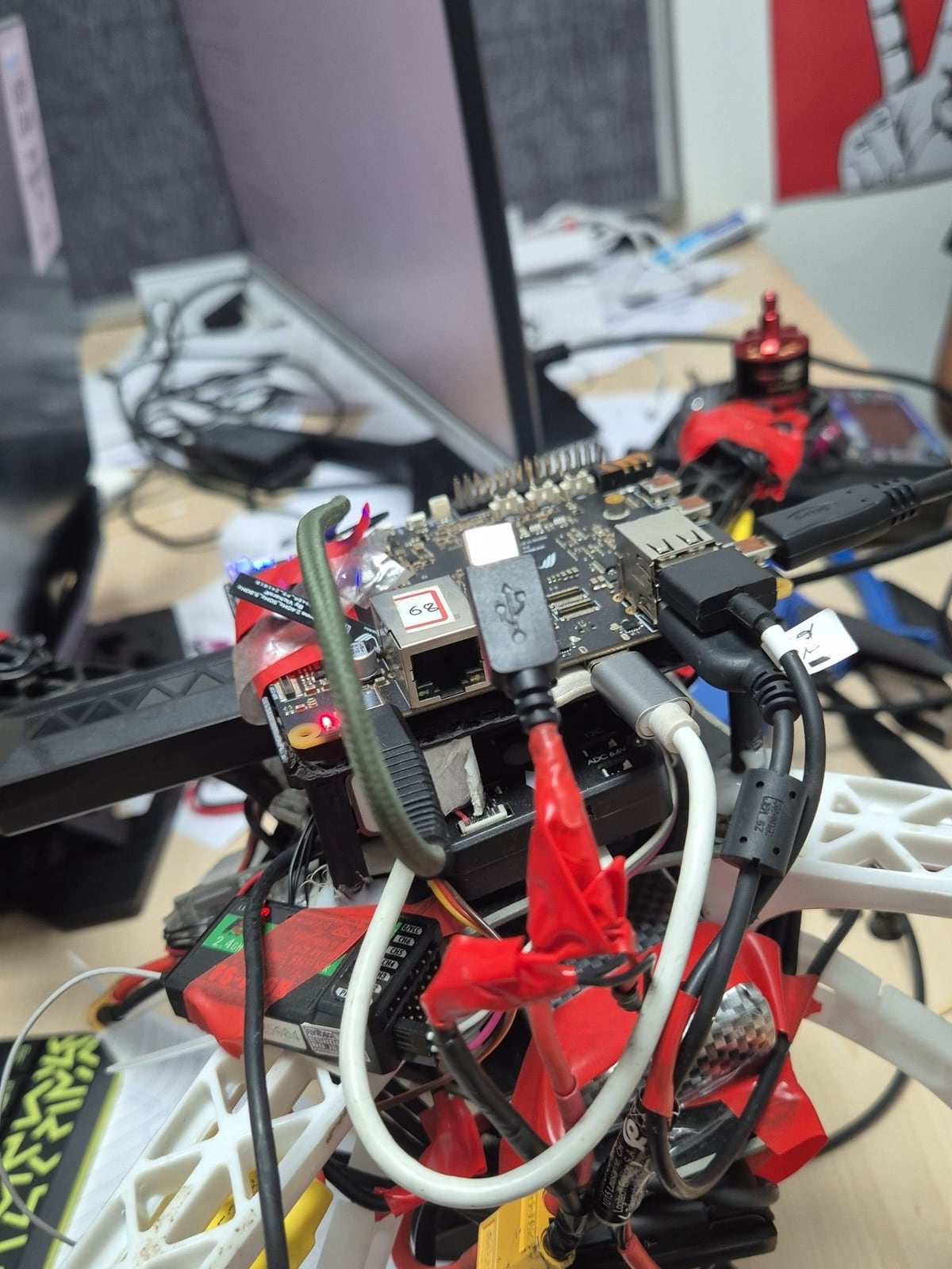 Close-up of the ANAV electronics stack on a lab desk, with USB and power leads taped in place.